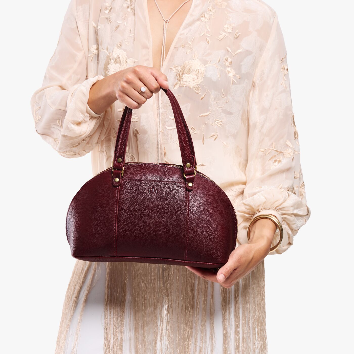 Cabernet*Small | Model holding a half circle crossbody bag with handles and removable crossbody strap