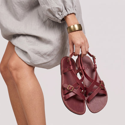 Marsala | Person wearing strappy leather sandals with two buckle accents