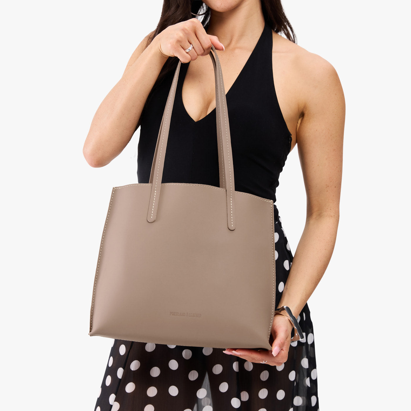 Stone*Medium | Model holding leather tote bag with matching leather handles