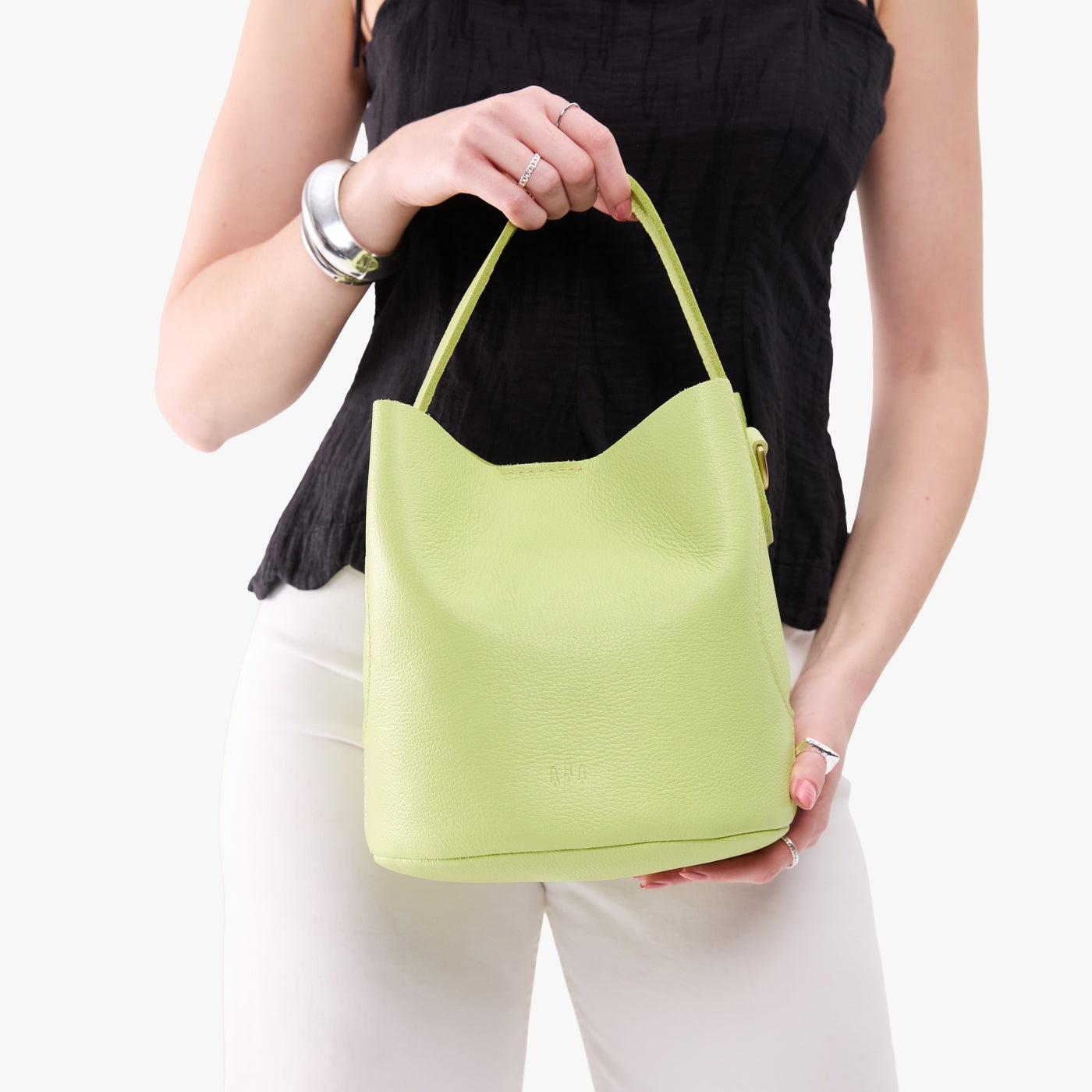 Shadow Lime*Large | Model holding symmetrical bucket bag with handle, latch closure, and removable crossbody strap