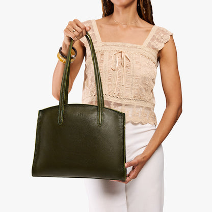 Pebbled Olive*Large | Model carrying leather tote bag with handles, adjustable crossbody strap, and two back pockets