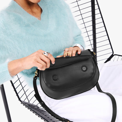 Black*Large | Model wearing a leather Crossbody with a flap and magnetic closure