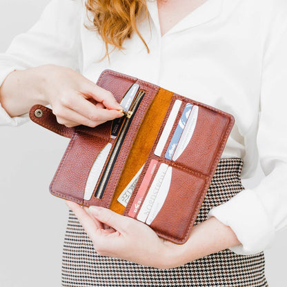Nutmeg | Model holding leather wallet with snap open