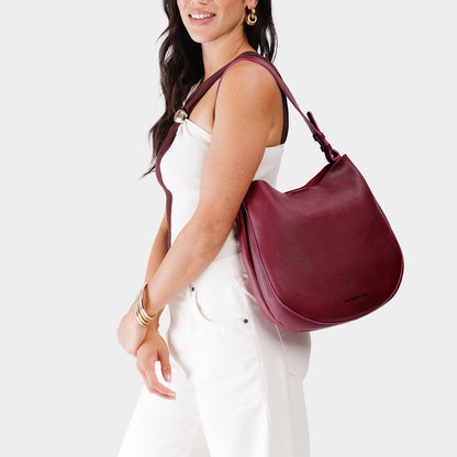 Orchid*Large | Woman wearing rounded shoulder bag with adjustable strap on a white background