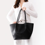 Black*Oversized | Model holding extra wide bucket shaped tote bag with matching leather handles