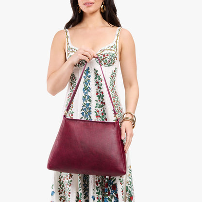Orchid*Large | Model holding large triangular shoulder bag with antiqued brass finished hardware